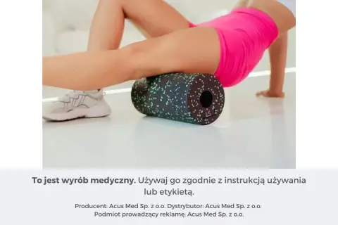 Kobieta wykonuje rolowanie mięśni ud za pomocą czarnego wałka z zielonymi kropkami.