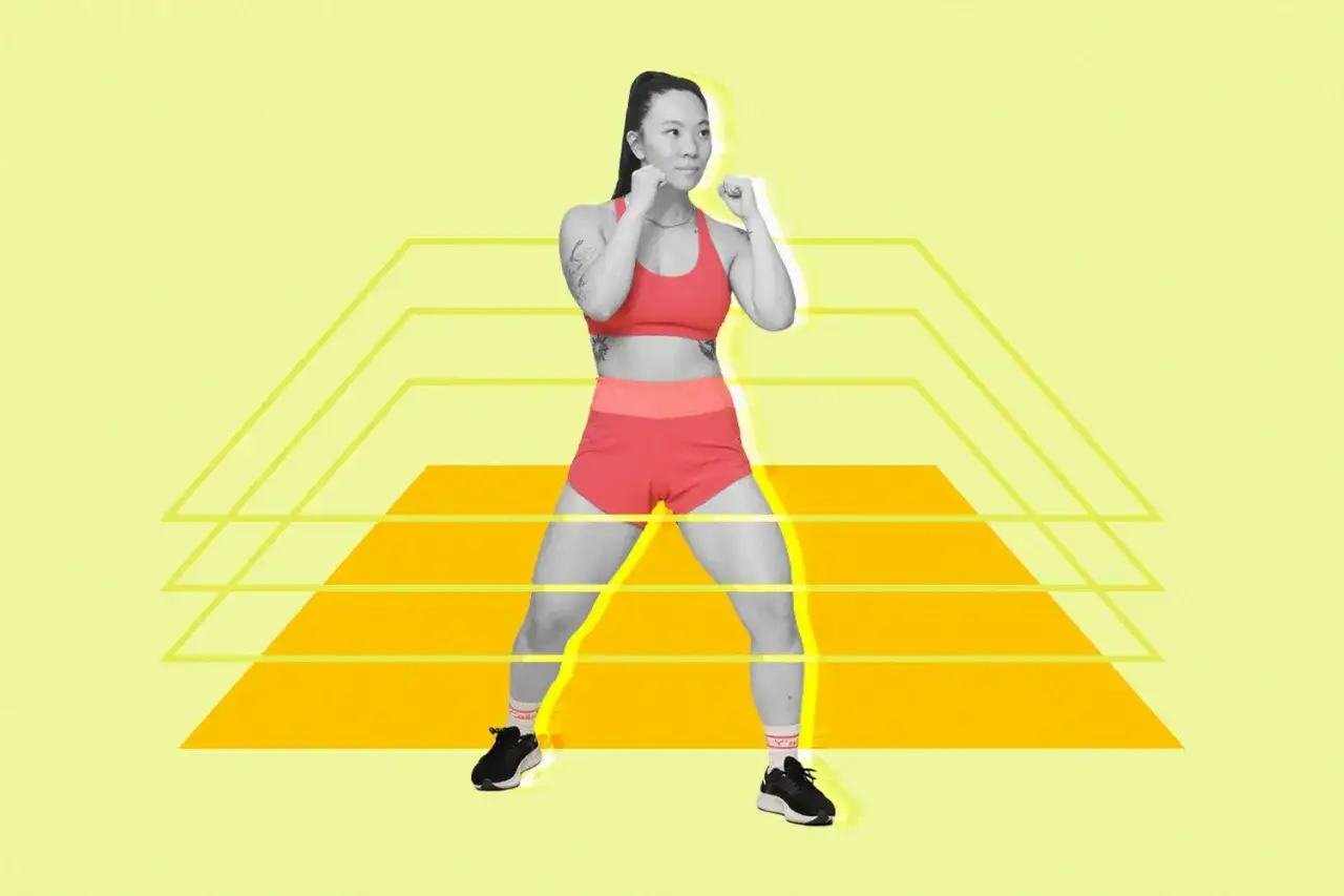 Kobieta w sportowym stroju wykonuje trening bokserski w domu, w pozycji gotowości do walki.