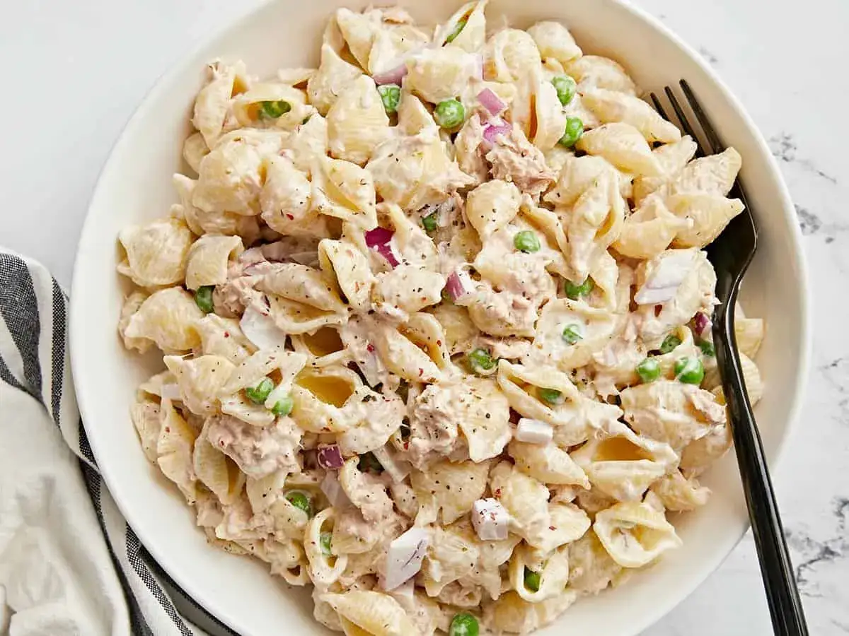 Pyszna pasta z tuńczyka i jajka z groszkiem i czerwoną cebulą, wymieszana z kremowym sosem. Idealna na szybki obiad.